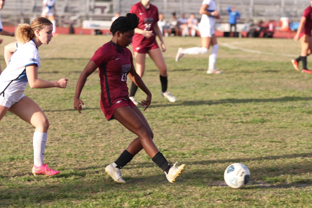 Concentrating, junior Breanna Gordon (22) kicks a soccer ball during a girls' varsity soccer game against Park Vista Community High School. The game ended in a tie; during the first half of the game MSD scored two points and during the second half MSD's opposing team, Park Vista Community High School, scored two points as well.