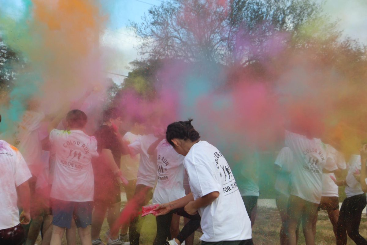 Immediately after the start signal, participants of Marjory Stoneman Douglas High School's Dance Marathon Color Run throw color powder while simultaneously bracing themselves on Saturday, Dec. 14. This year marked the club's fourth annual Color Run, where all money raised from the $35 registration fee went towards a Nicklaus Children's Hospital fundraiser. "My favorite part of color run is everyone throwing the color on each other, getting really messy and running around and acting like kids again," Dance Marathon Club sponsor Coral Bachen said.