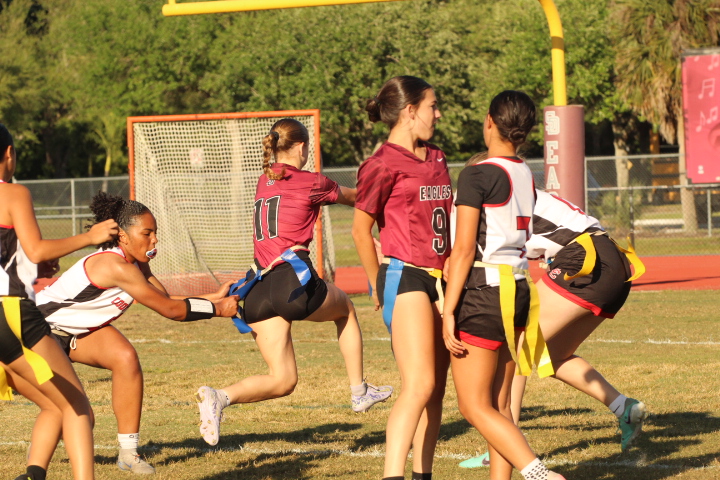 Running back and wide receiver Courtney Heymach (11) scores a touchdown, while rusher and wide receiver Audrey Haltiwanger (9) blocks a defender from grabbing her flag. The Eagles have not yet lost a game this season. "I love contributing to my team even if I do very little during the play," Haltiwanger said. "Whether it's sacking the quarterback or catching a touchdown, I just love playing and winning as a team."