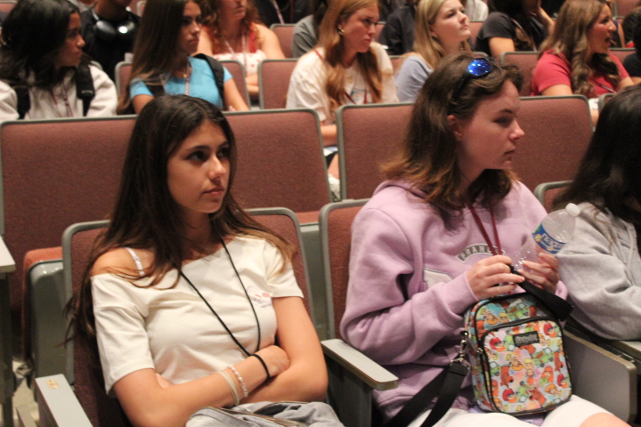 Listening to instructions on Friday, April 4, seniors Ella Kephart and Madison Cousans get ready to leave for Grad Bash in Orlando. Students attending Grad Bash had to meet in the auditorium after A lunch on the day of the event. "All of my friends were going and I haven't been on a roller coaster or amusement park since probably elementary school, so it was a fun experience," Kephart said.