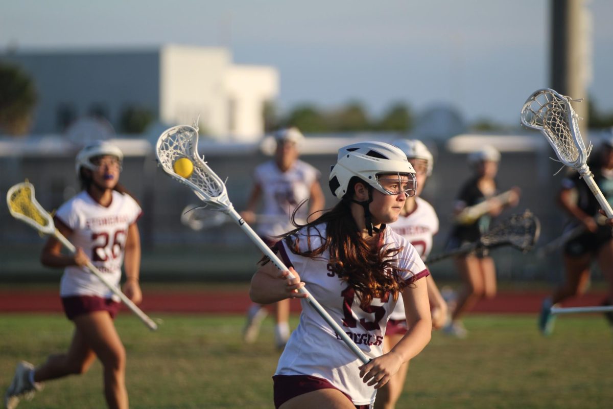 Midfielder Sammy Shortz (15) drives the ball towards the Archbishop McCarthy High School Mavericks' goal during their lacrosse game on Thursday, Feb. 20, at Cumber Stadium. The game resulted in a victory for the Lady Eagles, who won 19-5.