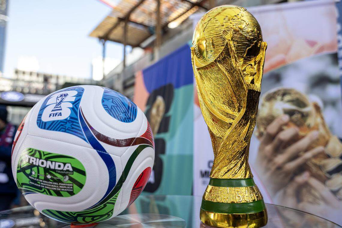 A replica of the FIFA World Cup trophy is displayed alongside a soccer ball during the FIFA World Cup draw watch party at the Power and Light District on Fri., Dec. 5, 2025, in Kansas City. Photo permission from Emily Curiel/TNS. 