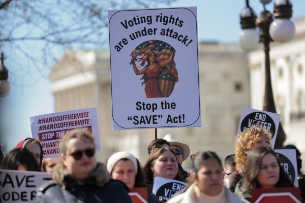 Attendees hold signs advocating against the SAVE America Act at a rally outside the U.S. Capitol on March 18, in Washington, DC. Members of congress joined leading voting rights advocates in rallying against the SAVE America Act. Photo permission from Heather Diehl/Getty Images/TNS.